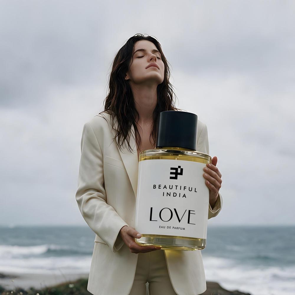 A woman holding Love Eau de Parfum by the sea