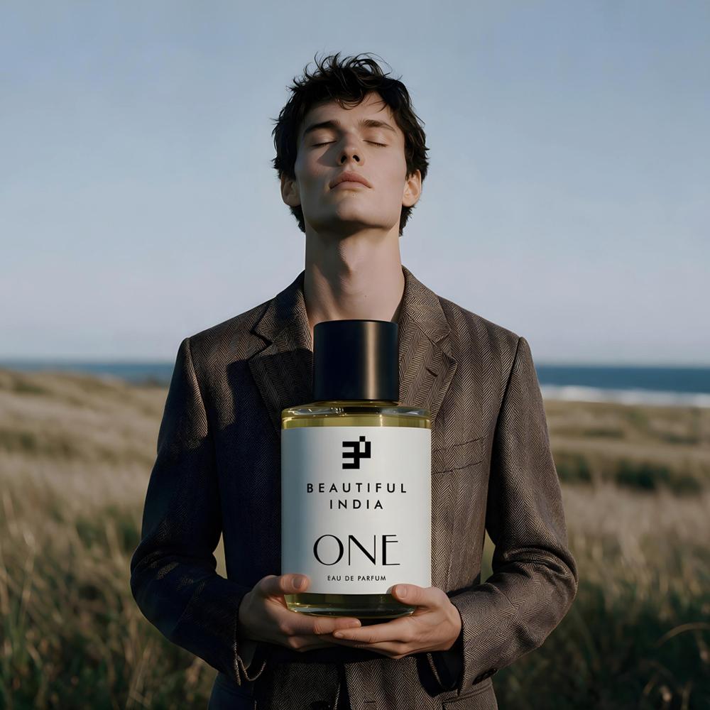 A man holding One Eau de Parfum in a coastal meadow